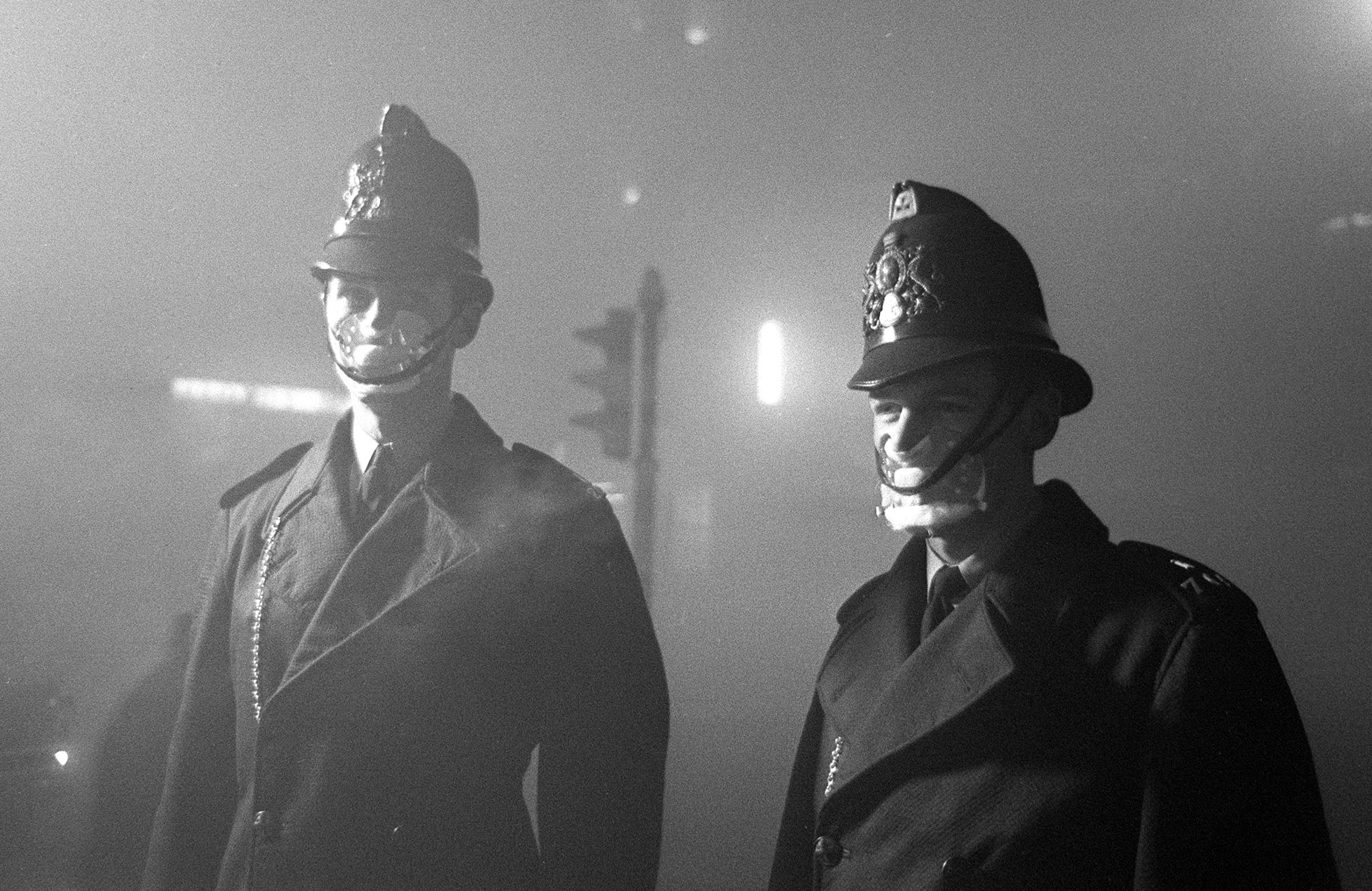 PC John Finn (right) from Snow Hill Police Station with a colleague. Both wear smog masks. Smog affected London up until the mid 60s when the clean air act finally caused London's Pea Soupers to be a thing of the past. 6th December 1962/Alisdair MacDonald /Daily Mirror/Getty Images