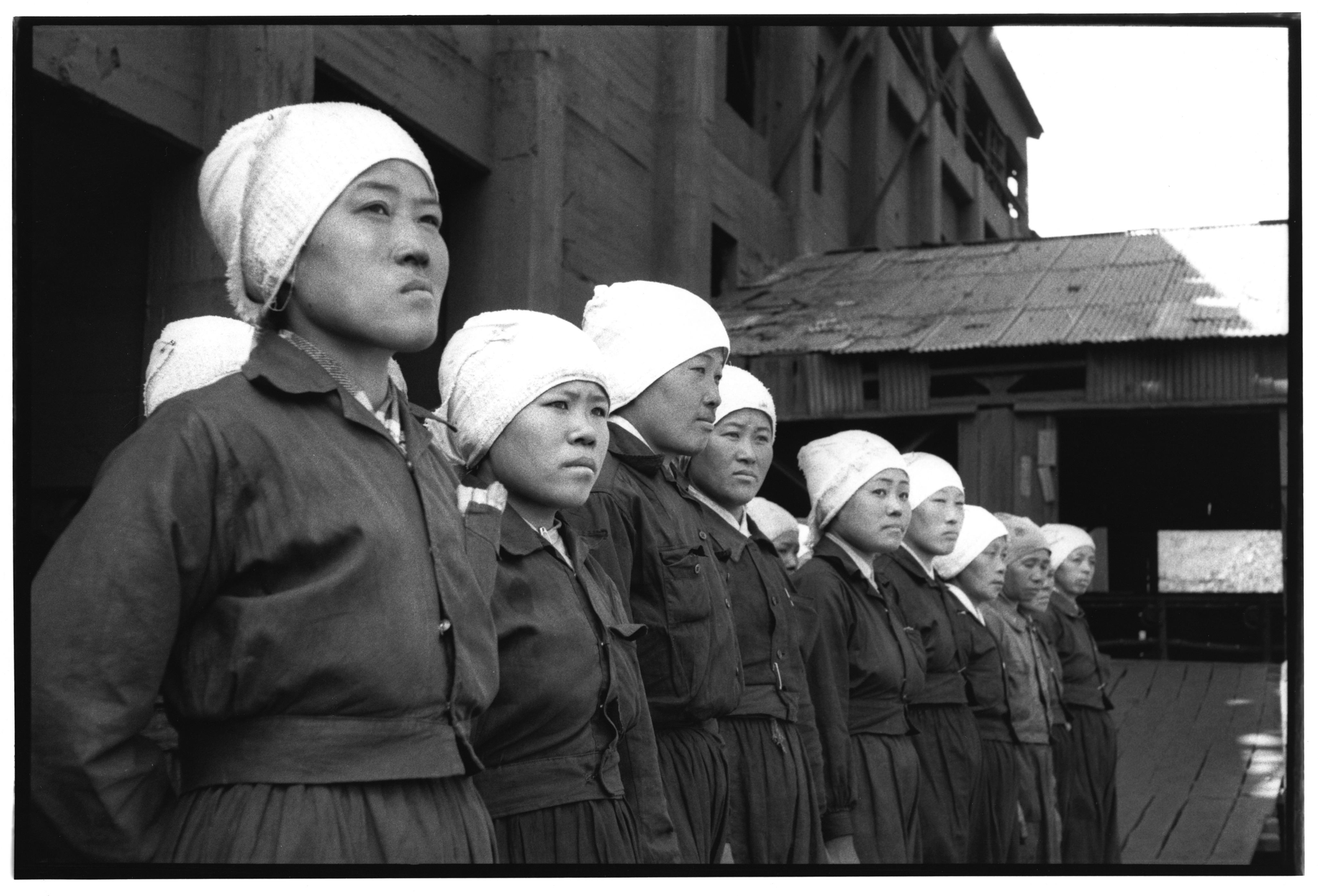 Female mine workers standing in formation/Corbis via Getty Images