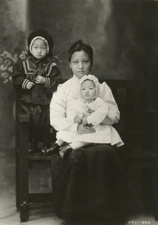 Anna May Wong seated in her mother's lap with her older sister standing, c. 1905/The Wisconsin Center for Film and Theater Research/Wikimedia Commons