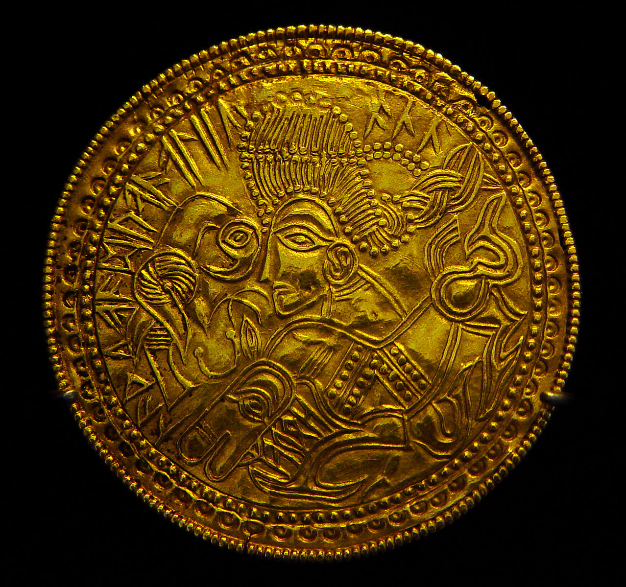 The Funen bracteate (DR BR42 = DR IK58), found in Funen, Denmark. The runic inscription is read as: houaz laþu aaduaaaliia a– or alternatively houaz / laþu aa duaaalii(a) /  al(u). According to the display at the National Museum of Denmark, houaz is interpreted as "The High One", a name of Odin/Wikimedia Commons