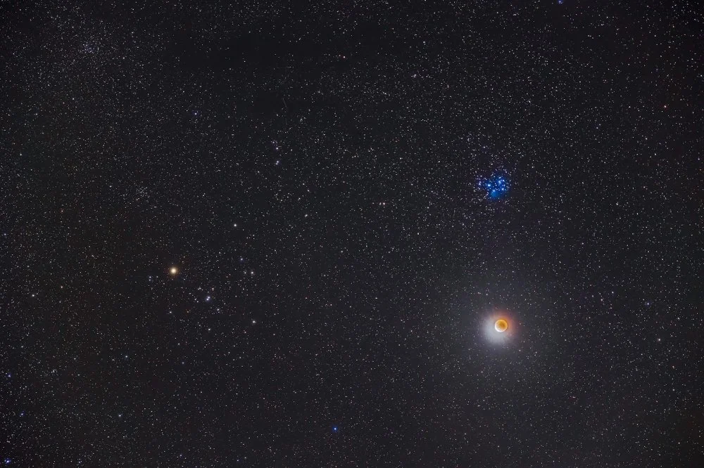 Плеяды (звездное скопление) и под ними Лунное затмение 19 ноября 2021 года/ Getty Images