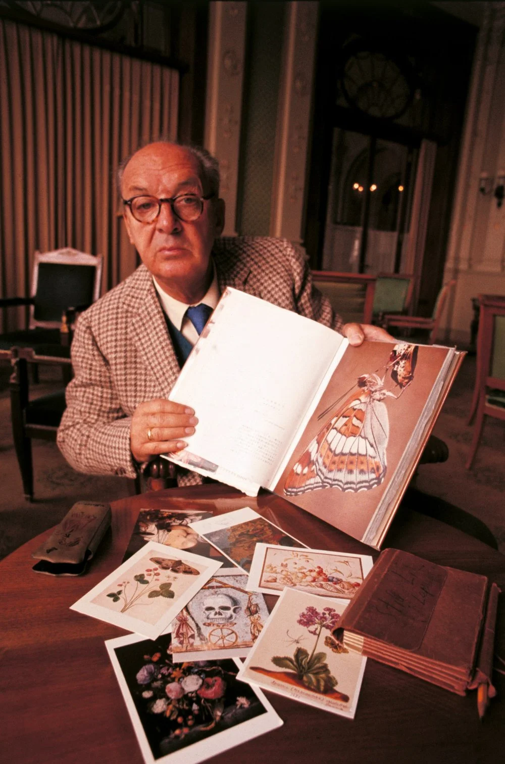 Russian-born American writer Vladimir Nabokov showing some drawings leaning on a table. Montreux, October 1969/Giuseppe Pino/Mondadori via Getty Images