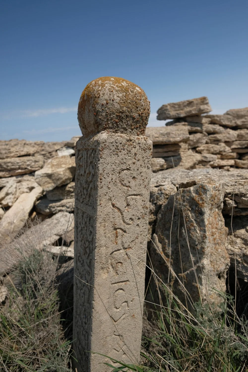 A carved headstone, with verses from the Qur'an, on one of the many graves of Kazakh people dating to the 1930s when Stalin's policies resulted in famine in Kazakhstan and people migrated south located amid ancient burial mounds and funerary of Kazakh nomad tribes located at the Ustyurt Plateau, a transboundary clay desert which drops steeply to the Aral Sea/Alamy