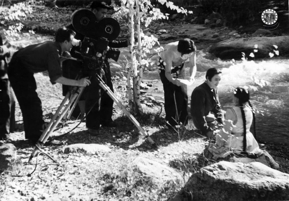 «Махаббат туралы аңыз» фильмінің түсірілім барысы. Алматы студиясы. Режиссерлері — Шәкен Айманов, КСРО Халық әртісі және Карл Гаккель. Оңнан солға қарай: Баян — Шара Жандарбекова, биші әрі педагог, Қазақ КСР Халық әртісі; Қозы Көрпеш — Төлеген Арғынбеков /  ҚР ОМ КФДЖА