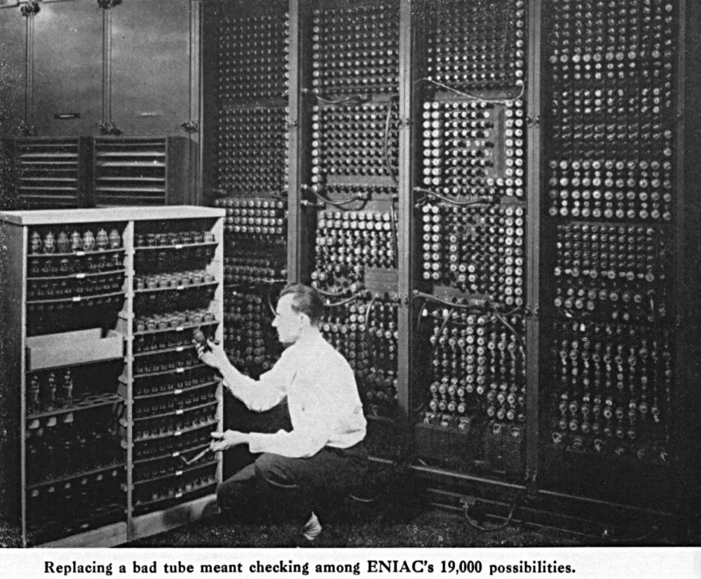 M. Weik. The ENIAC Story. U.S. Army Photo. A technician changes a tube. Caption reads: Replacing a bad tube meant checking among ENIAC's 19,000 possibilities. Center: Glenn A. Beck/Wikimedia Commons