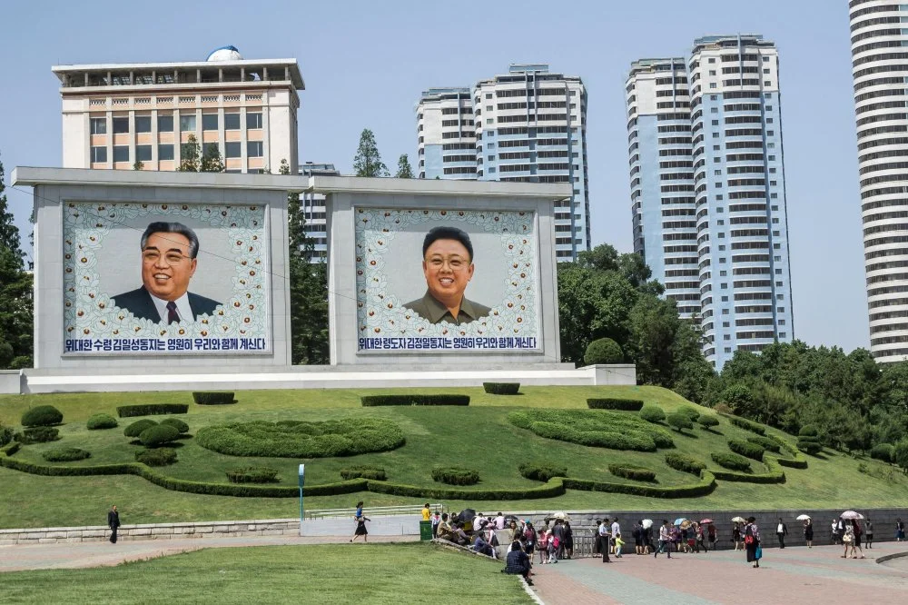 Марқұм көшбасшылардың портреттері Ким Ир Сен (сол жақта) және Ким Чен Ир (оң жақта). Пхеньян орталығы / Alamy
