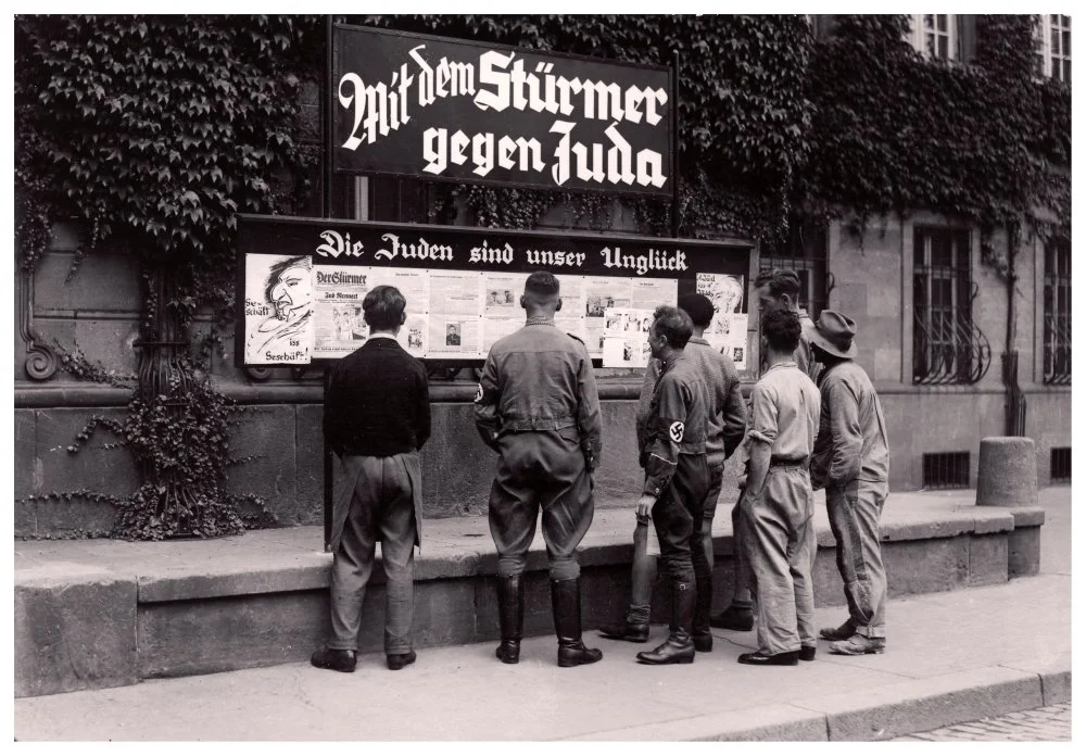 NSDAP members and a motley dissolute group of German men reading antisemitic newspaper. 1930s / Alamy