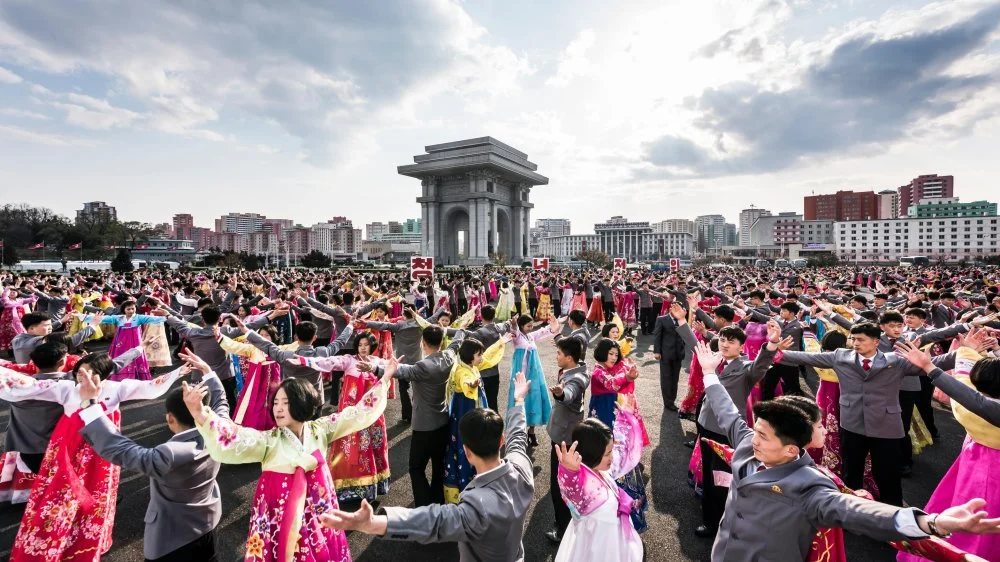 Массовые танцы рядом с Тримфуальной аркой в Пхеньяне/Alamy