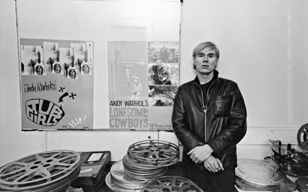 Andy Warhol at the Factory with posters for Tub Girls (1967) and Lonesome Cowboys (1968). (Photo by Jack Mitchell/Getty Images)