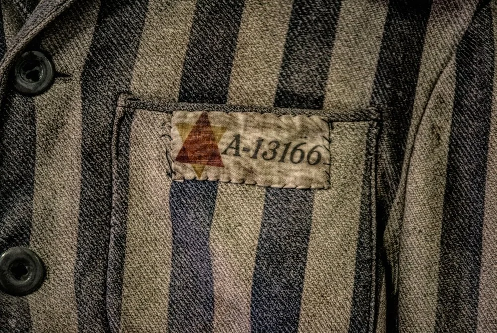 Uniform of a Jewish prisoner in a concentration camp. Museum of Nazi terror and the Holocaust. Auschwitz, Poland/Shutterstock