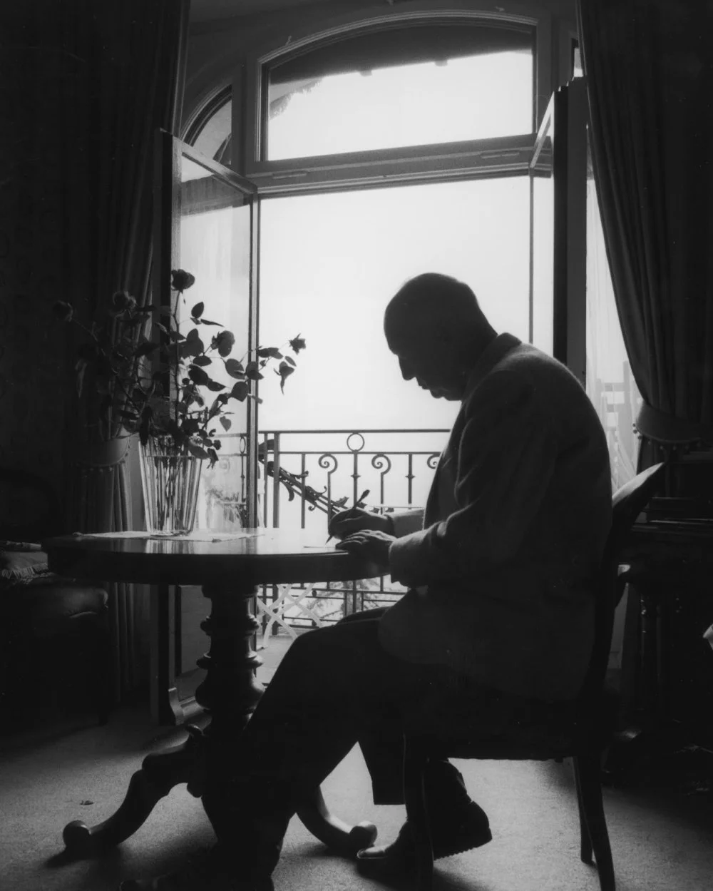 Vladimir Nabokov writes in a notepad while sitting at a table in his suite at the Montreux Palace Hotel, Switzerland 1965 /Horst Tappe/Getty Images