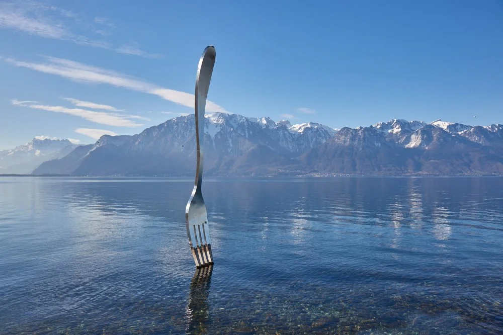 Huge steel fork art installation in Lake Geneva part of the Alimentarium food museum in Vevey, rippling water surface/Shutterstock