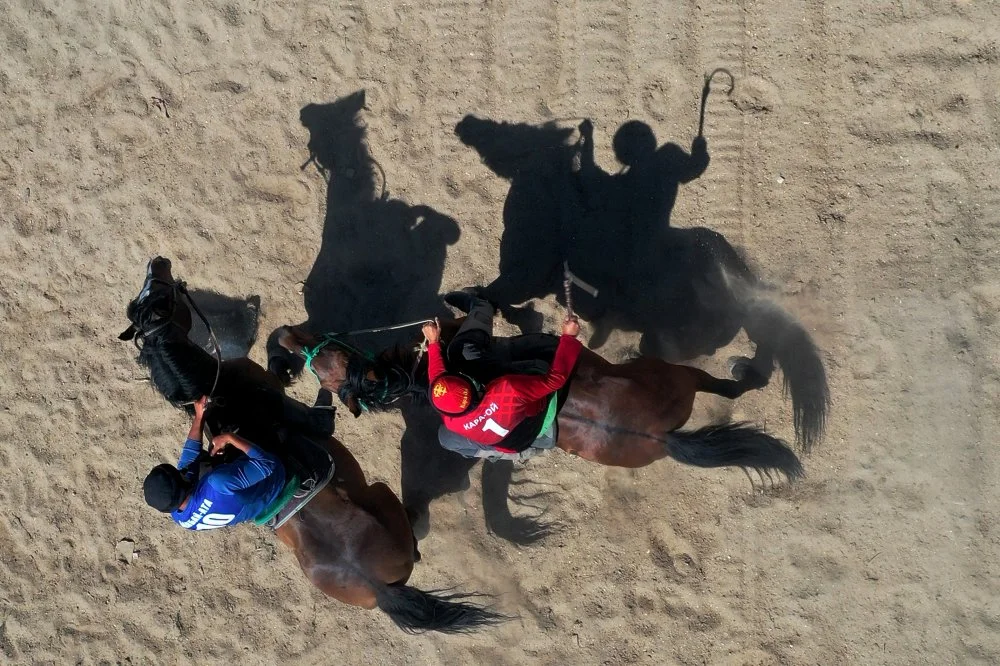 This aerial picture shows horse riders playing the traditional Central Asian sport of "Kok-Boru" (Gray Wolf) or "Buzkashi" (Goat Grabbing), a medieval Kyrgyz warrior, in Cholpon-Ata on June 1, 2024/VYACHESLAV OSELEDKO/AFP via Getty Images