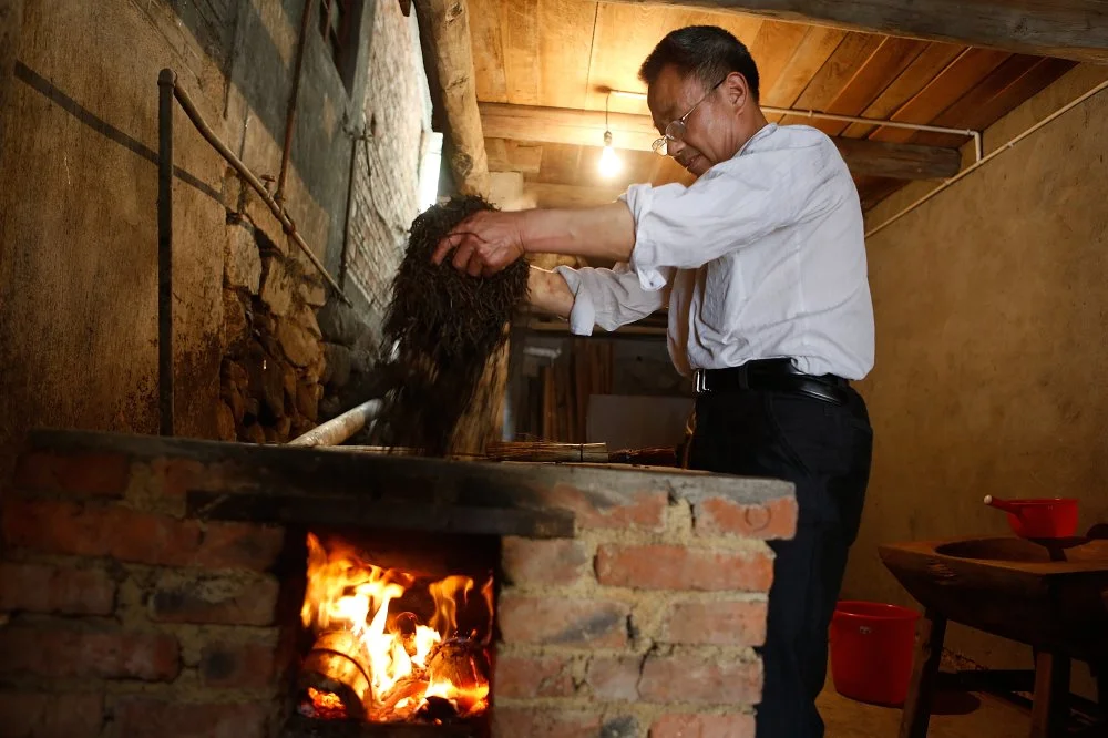  Wuyi Mountain Tea Industry Liang Junde, producer of top red tea Jinjunmei, produces Lapsang Souchong red tea, at his tea factory in the village of Tongmuguan, an area famous for the origin of red tea, on May 11, 2012 in Wuyishan, Fujian province, southeastern China/Getty Images